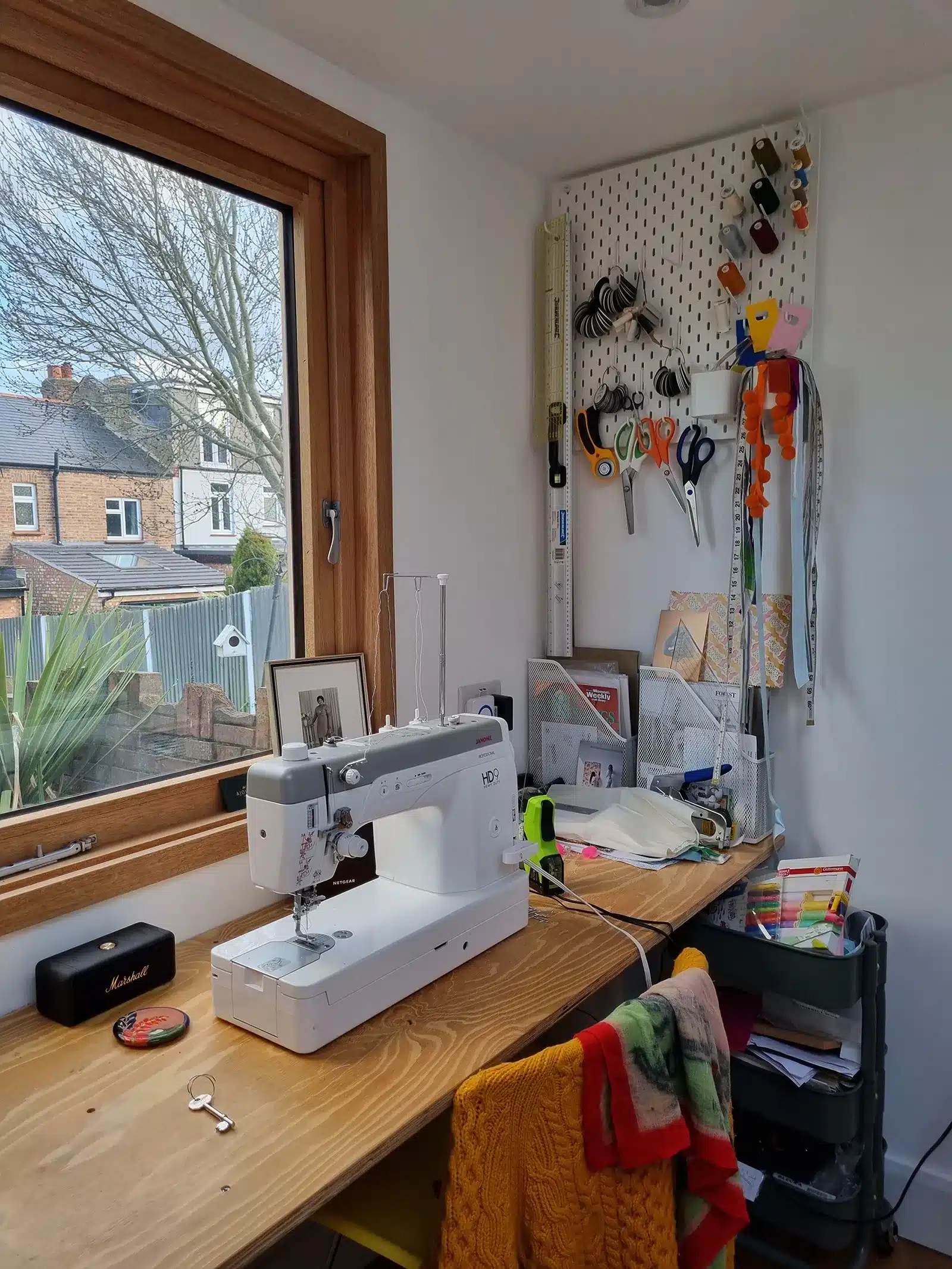 A sewing room with a sewing machine and a window.