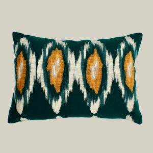 A green and yellow Mind the Gap - Ikat, Green & Orange pillow with an ikat design.