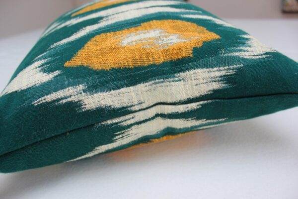 A Mind the Gap - Ikat, Green & Orange pillow with a yellow and green pattern.