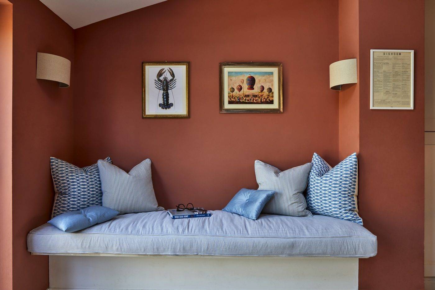 A room with red walls and a blue bench.