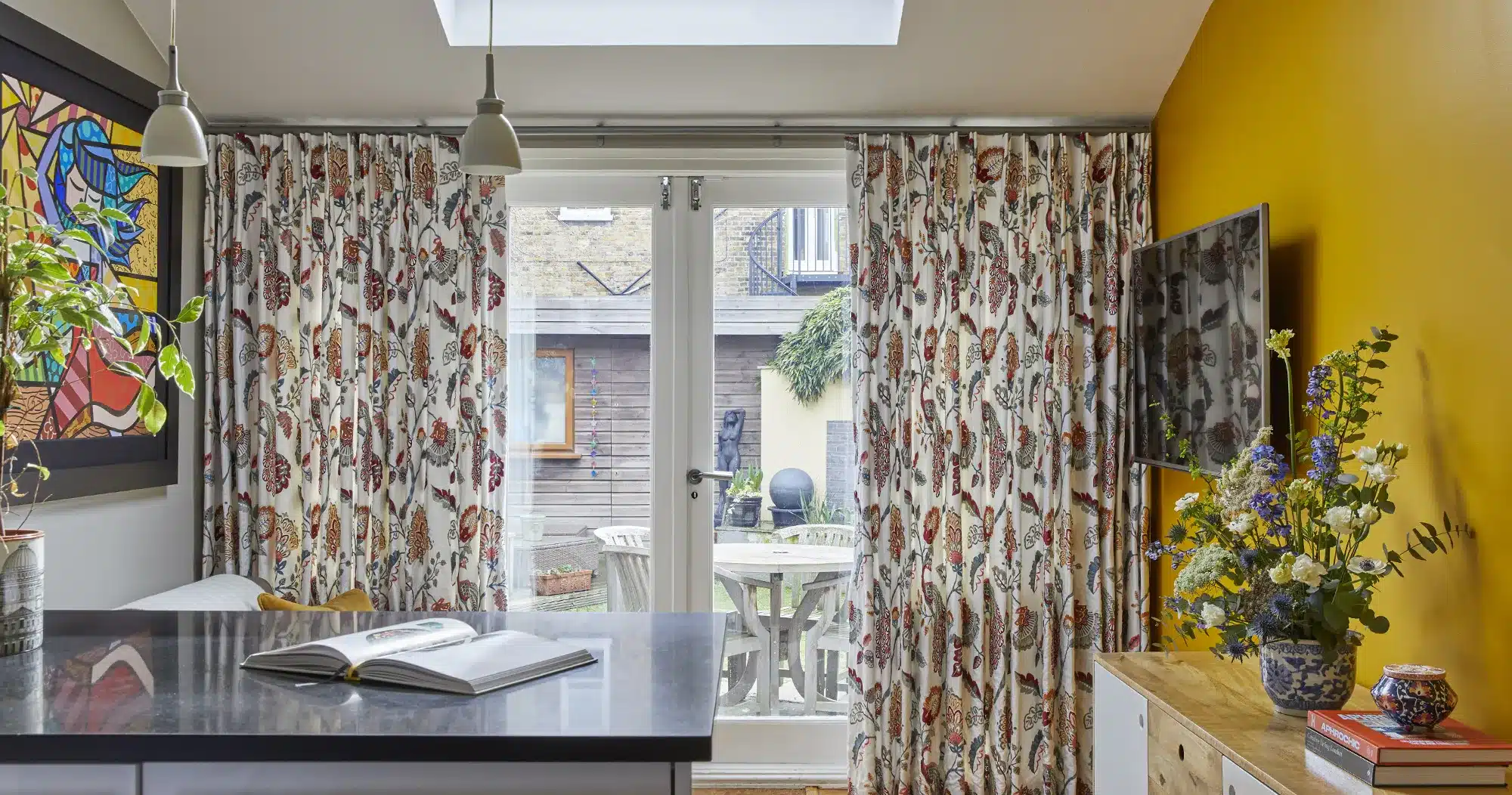 A kitchen with yellow walls and yellow curtains.